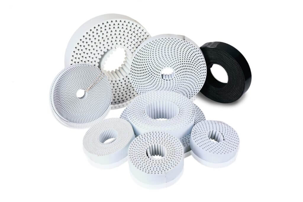 Coiled Optiset PU timing belts in multiple diameters showing the polyurethane toothed profile